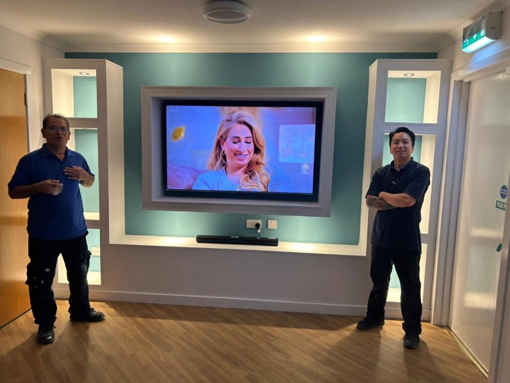 maintenance team next to the media wall