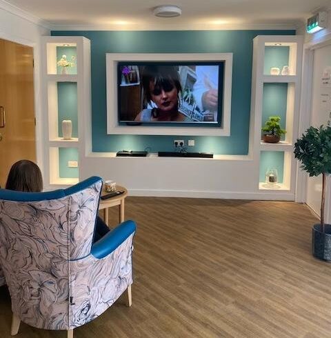 resident in a chair watching the new media wall