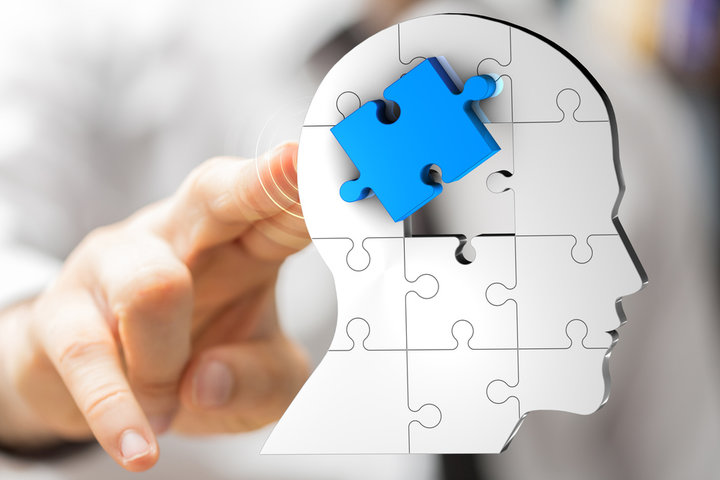 jigsaw puzzle of a head and the blue bit in the middle symbolising the brain 