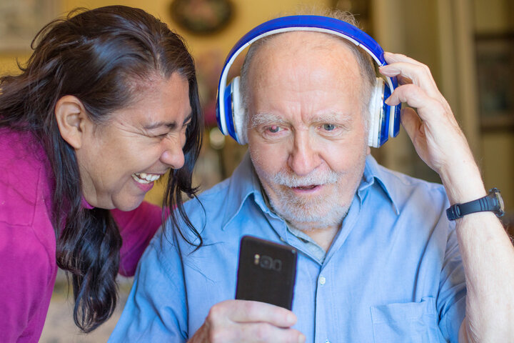 elderly man with headphones on with staff 