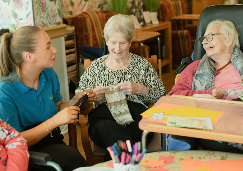 carer knitting with two elderly residents