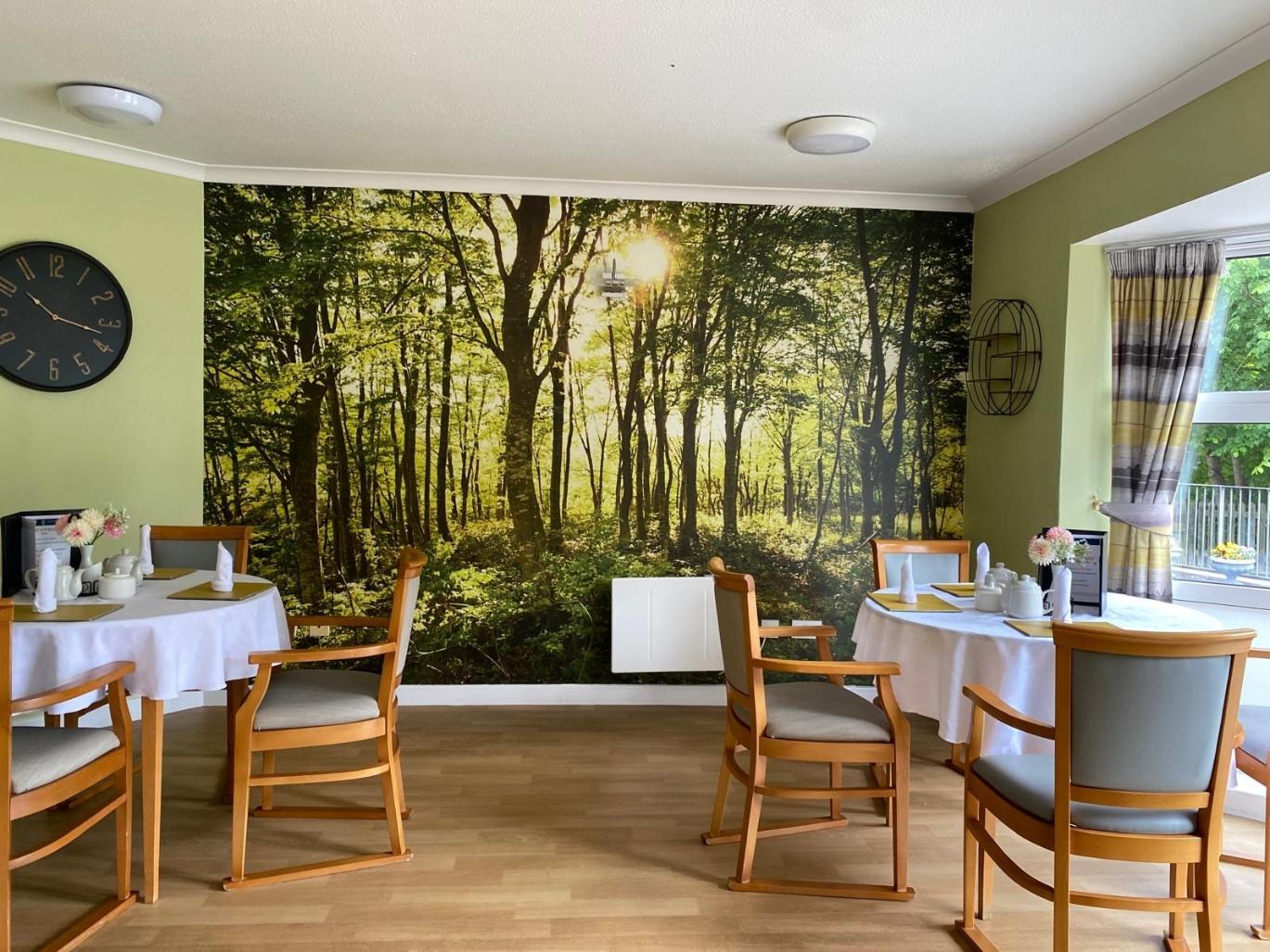 dining room with forest scene on wall