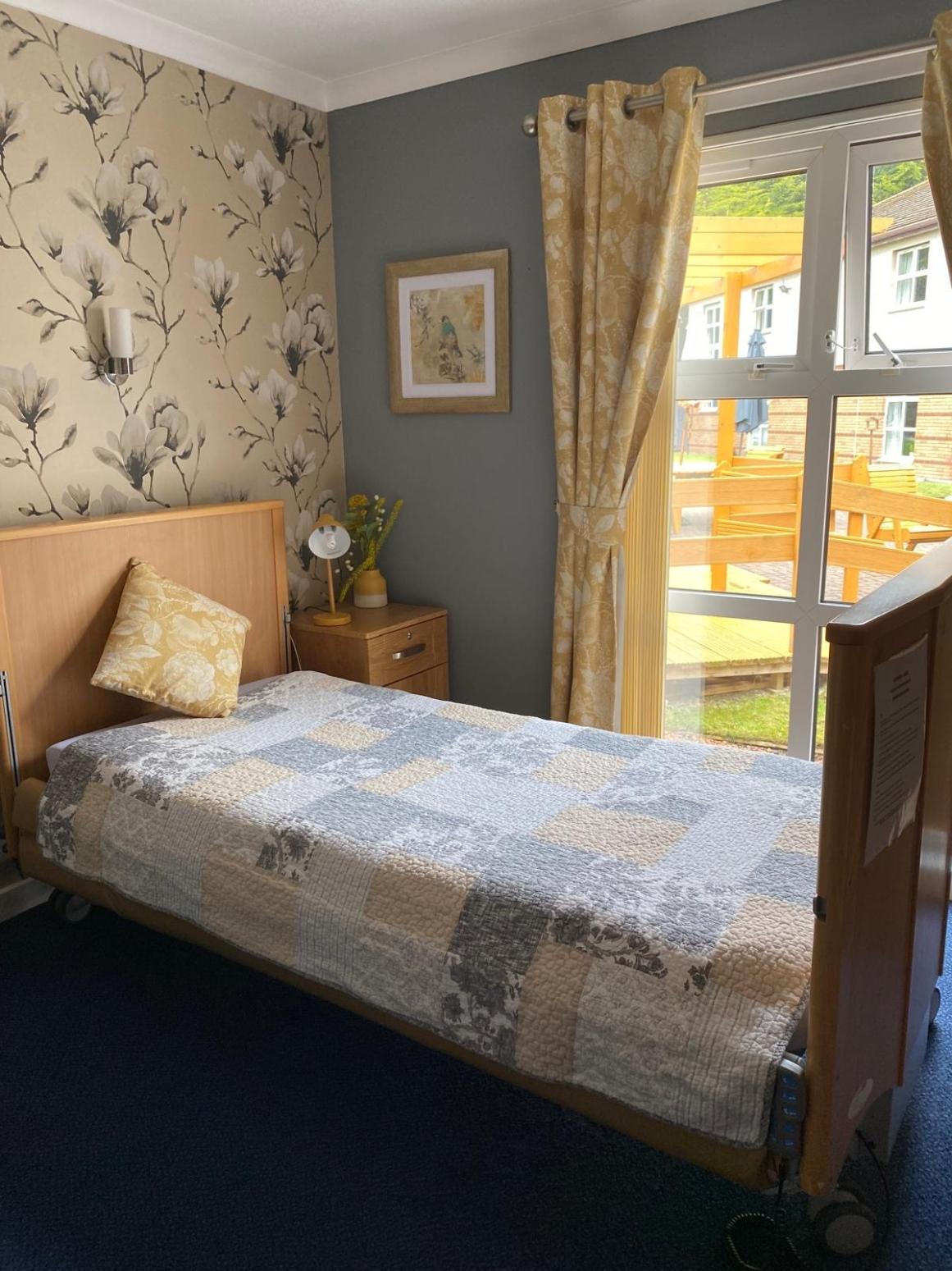 care home bedroom with grey and yellow decoration