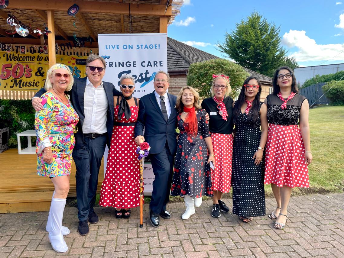 group of smiling people outside at music festival